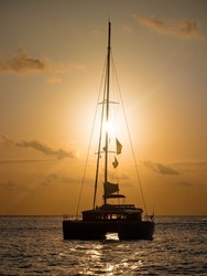 Sunset in the Indian Ocean. Silhouette of a sailing catamaran anchored against the backdrop of the evening sun