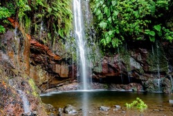 Risco waterfall in Rabacal is 100m high, with rocks covered with small plants and a small natural pool in Madeira Portugal