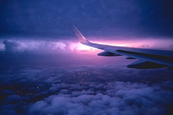 Flying on plane in a storm at night over Dallas with lightning in the horizont, USA