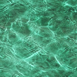 Abstract seamless green texture by sunlight on a water surface