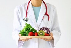 Doctor holding fresh fruit and vegetable, Healthy diet, Nutrition food as a prescription for good health. (Selective Focus) 