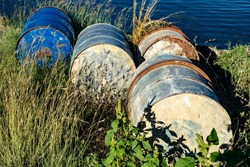 Tin barrels on the grassy shore of the lake
