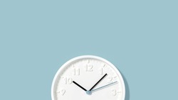 White plain analogue wall clock on trendy pastel blue background. Five past ten oclock. Close up with copy space, time management concept and opening or closing time