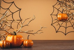Orange halloween pumpkins with golden spider webs and branches. happy halloween party decoration. copy space