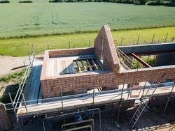 Up close aerial drone view of a barn conversation showing scaffolding and brickwork