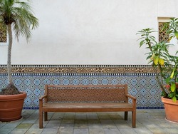 Wooden bench in the park against the wall. Carved bench.
