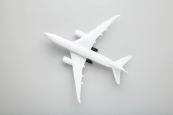 Model white airplane on a grey background. Travel concept