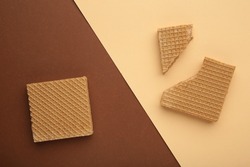 Square chocolate wafer biscuits on brown colorful background. Top view.