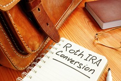 Roth ira conversion memo near retro briefcase and glasses.
