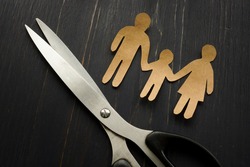 Parental alienation concept. Figures of family and scissors as symbol of divorce.