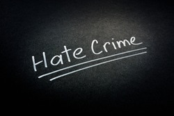 Hate crime words on the dark surface.