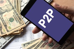 Smartphone in hand with message P2P. Peer to peer lending concept.