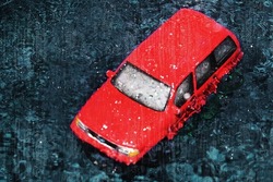 Car during the rain drowns in a huge puddle formed on street as a result of the flood. Photo effect: drops water on window glass
