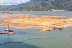 Reclamation of artificial island for Hong Kong Port or Boundary crossing facilities in progress (part of project of HK-Macau-Zhuhai Bridge (July 2014). Lantau island in background