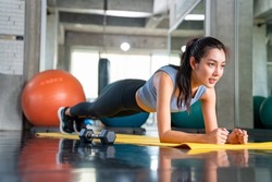 Healthy Asian athlete woman in sportswear do plank workout exercise body weight lifting at fitness gym. Strong female body building muscle weight training at sport club. Health care motivation concept