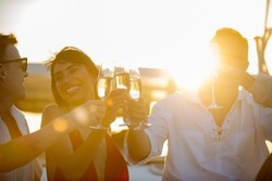 Blurred Group of People man and woman friends enjoy party drinking champagne together while catamaran boat sailing at summer sunset. Male and female relax outdoor lifestyle activity on travel vacation