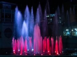 Water Fountain Spurting Water with Colored Lights in the Dark Night