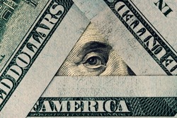 President Franklin's eye in a triangle of hundred dollar bills. The all-seeing eye symbol concept. Words visible on banknotes: America, dollars, united.