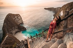 Beautiful girl on the background of Kelingking beach, Nusa Penida Indonesia. A young woman is traveling in Indonesia. Nusa Penida is one of the most famous tourist attraction place to visit in Bali