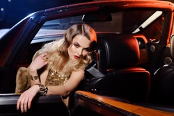 Retro portrait of a beautiful luxury Gatsby woman in black cabriolet car. Vogue fashion style and smoke. Hollywood look. Copy Space