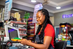 Closeup of a customer using her credit card to pay for goods brought from supermarket