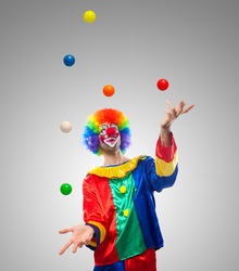 Funny clown juggling many balls