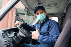 Masked truck driver giving thumbs up during coronavirus pandemic