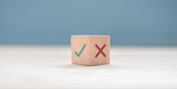 True and false symbols accept rejected for evaluation, Yes or No on wood blogs on blue background.