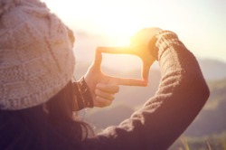 Future planning, Close up of woman hands making frame gesture with sunrise on mountain, Female capturing the sunrise, sunlight outdoor.