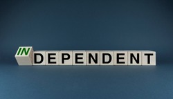 Independent or dependent. Cubes form the words Independent or dependent. The concept of independence in business, international relations and personal life