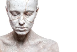 Art portrait of woman covered in clay isolated over white background. Woman face like cracked earth