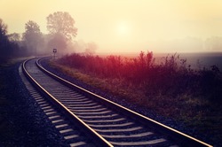 Railroad track during autumn foggy morning in countryside