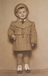 A little boy in a coat, an old picture of 30 years of XX century