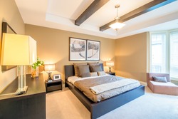 Modern bright bedroom interior with designer pillows in a luxury house, hotel.