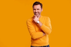 Portrait of fashionable handsome man posing on the yellow studio background, smiling. Casual fashion for men. A lot of copy space.   