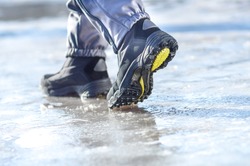 male or female winter boots walking on snowy sleet road