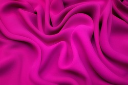 Close-up texture of natural red or pink fabric or cloth in same color. Fabric texture of natural cotton, silk or wool, or linen textile material. Red canvas background.