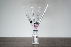 A vaccine vial with 4 syringes. A fourth dose Covid-19 vaccine booster shot concept.