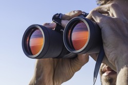 A man looking through the binoculars

