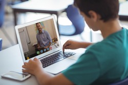 Caucasian schoolboy using laptop on video call with male teacher. Online education staying at home in self isolation during quarantine lockdown.