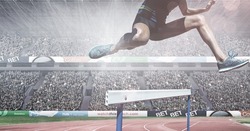 Composite image of caucasian low section of male athlete jumping over hurdles against sports stadium. sports, fitness and competition concept