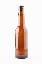 Image of brown glass full lager beer bottle with crown cap, with copy space on white background. Drinking alcohol, refreshment and lager day celebration concept.