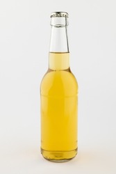 Image of clear glass full lager beer bottle with crown cap, with copy space on white background. Drinking alcohol, refreshment and lager day celebration concept.