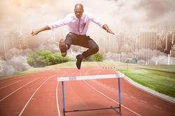 Businessman jumping a hurdle against composite image of racetrack in city