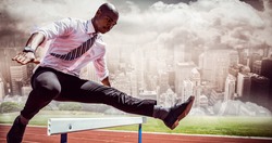 Businessman jumping a hurdle against composite image of track against city