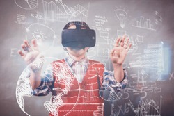 Technology icons against boy using a virtual reality device