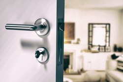 Closeup of wooden door with metallic doorknob against view of living room