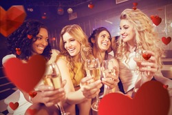 Pretty girls holding champagne glass against love heart pattern