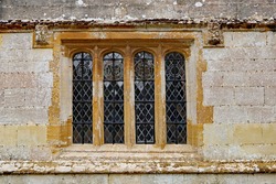 An old leaded window with a concrete frame in an old English country house