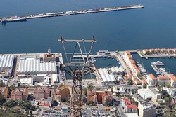 View of a cable car pylon with Gibraltar harbour in the background.